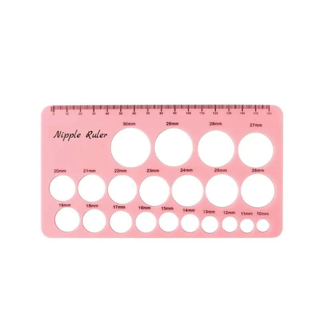 Pink plastic nipple ruler template with circular cutouts of various sizes and printed measurement markings, shown on a plain white background.